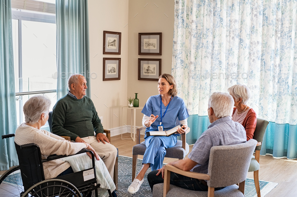 Nurse talking to senior people during group therapy Stock Photo by Rido81