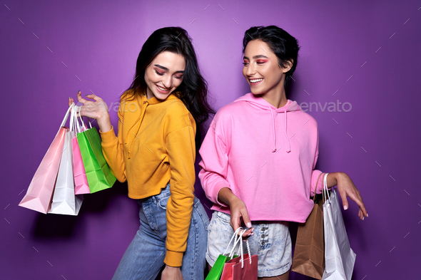 Two Happy Girls Friends Shoppers Holding Shopping Bags On Purple Background Stock Photo By Insta Photos