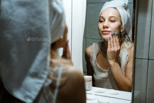 Use Wash Off Face Mask, Using Peel-Off Mask Correctly. Young woman in towel on her head wash face