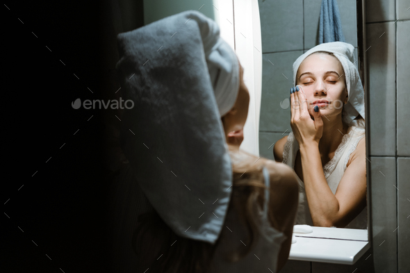 Use Wash Off Face Mask, Using Peel-Off Mask Correctly. Young woman in towel on her head wash face