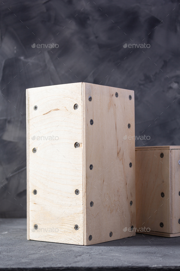 Wooden cube or plywood box near wall background texture. Abstract art or construction concept