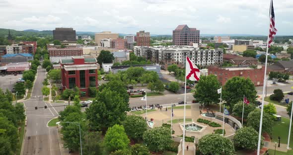 Huntsville, Alabama skyline with drone video moving up showing flags. alt
