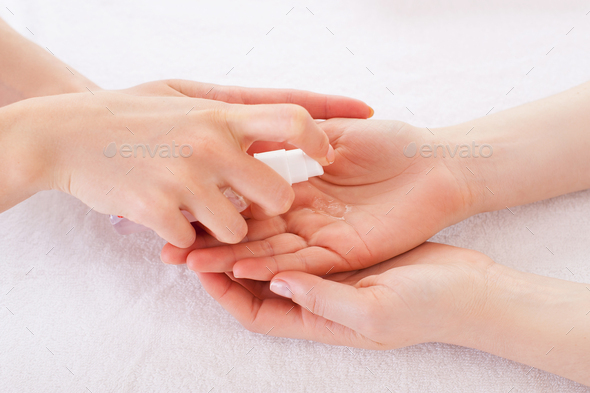 Applying antiseptic. Close-up of manicure master spraying antiseptic on female palm