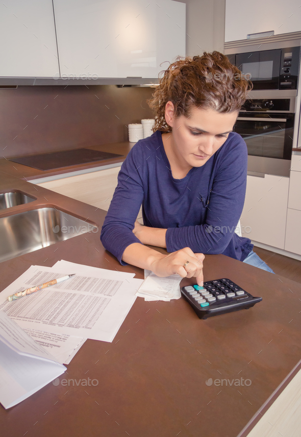 Unemployed and divorced woman with debts reviewing her monthly bills