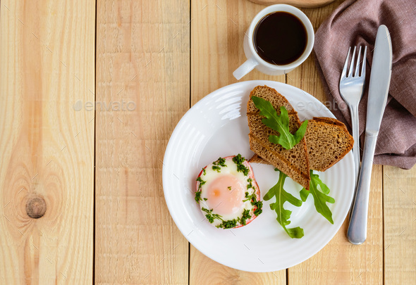 Scrambled eggs, baked in a ring bell pepper, toast, arugula leaves and a cup of coffee
