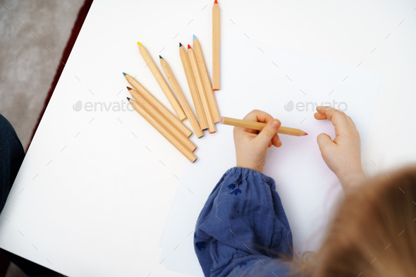 Little girl drawing on big white sheet of paper top view Stock Photo by  FabrikaPhoto