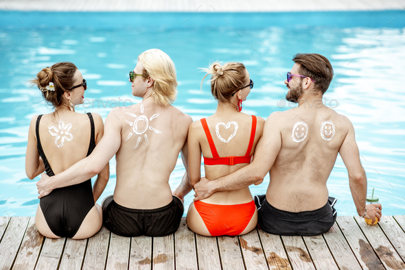 Friends with sun cream on the swimming pool outdoors - Stock Photo - Images