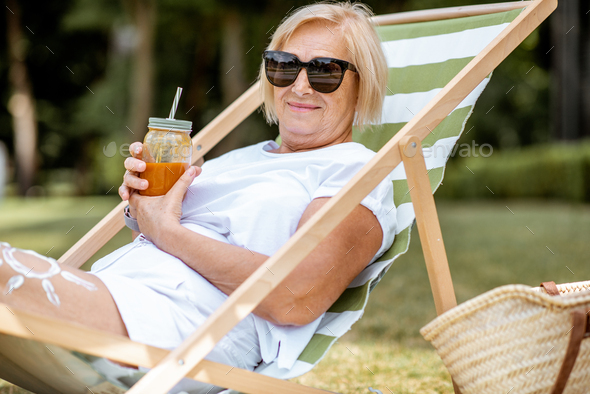 Senior woman on the sunbed outdoors - Stock Photo - Images