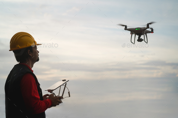 Man engineer pilot flying with drone - Video surveillance and industrial inspection concept