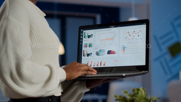 Close up of dark skin woman typing on laptop standing in start up