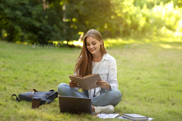 Beautiful Teen Girl Reading Book In Park, Preparing For High-School Lessons Outdoors