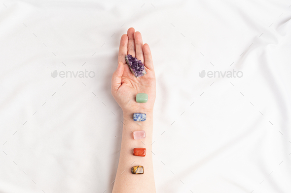Healing reiki chakra crystals on woman's hands. Gemstones for wellbeing, meditation, relaxation - Stock Photo - Images
