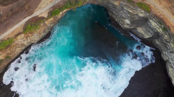 Rock Coastline. Stone Arch Over the Sea. Broken Beach, Nusa Penida, Bali, Indonesia. Aerial View  alt