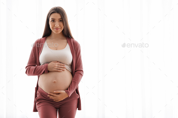 Cute Young Expectant Woman Touching Her Naked Belly While Posing