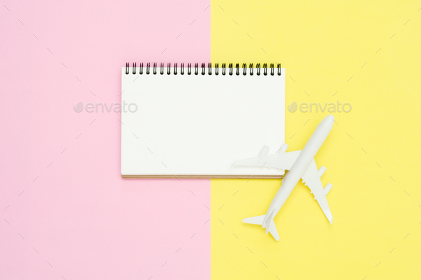 Top view mockup of blank paper notebook, pen, pastel leaf, roses and plane.