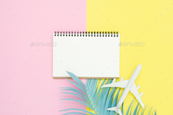 Top view mockup of blank paper notebook, pen, pastel leaf, roses and plane on pink yellow pastel.