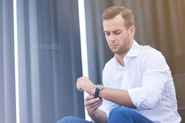 Businessman watching the time in his wear watches,brunette businessman  checking the time on his wrist watch, executive looking at the time on his  wris Stock Photo - Alamy