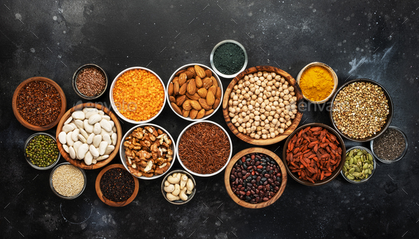 Selection of superfoods, legumes, cereals, nuts, seeds in bowls - Stock Photo - Images
