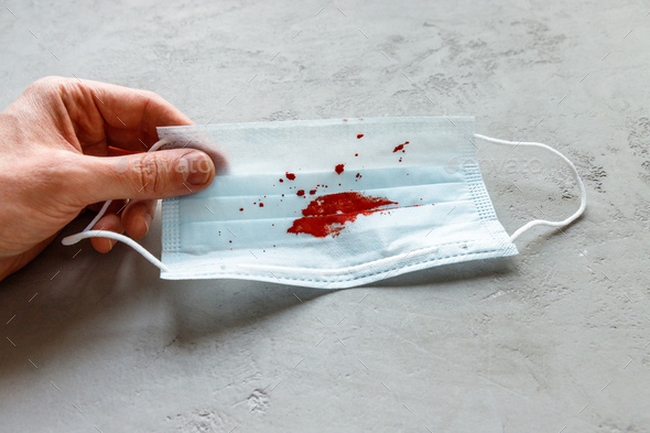 Man holding facial medical face mask with coughing blood