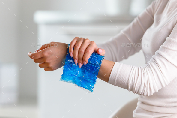 Woman applying cold compress to a her painful wrist