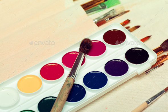 splashes of watercolor paint and painting supplies close up Stock Photo by  FabrikaPhoto