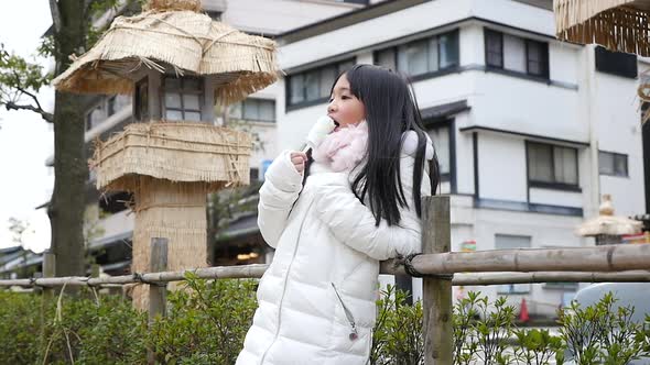 Little Asian Girl Smiling  And Eating Ice Cream Outdoor  alt