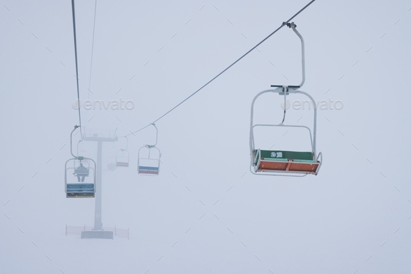 Cable cars hang on cables in a silent fog