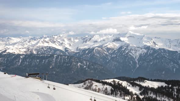 Snow slopes at ski resort and ski lift in mountains. Outdoor tourism.