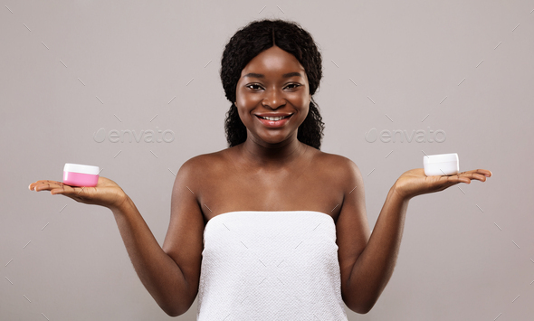 Best Cosmetics For Body Care. Beautiful African Lady Holding Jars With Cream