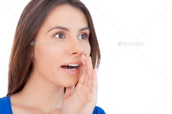 Shocking news! Surprised young woman shouting and holding hand near mouth while isolated on white
