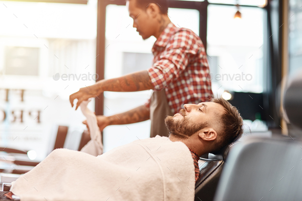Handsome bearded man sitting in the barbershop