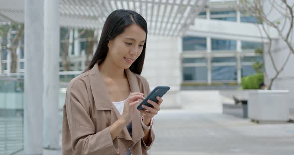 Woman use of mobile phone in city alt