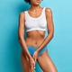 Unrecognizable woman wears white top and panties, has slim perfect body  shape, tanned healthy skin, Stock Photo by wayhomestudioo