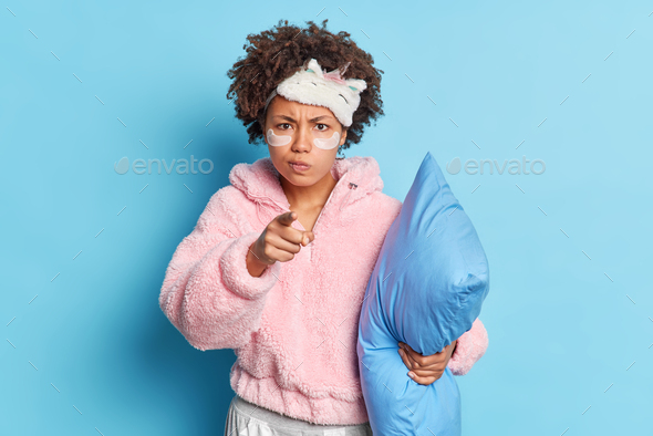 Irritated Curly Haired Young Woman Points Angrily At Camera Blames You That She Woke Up So Early 