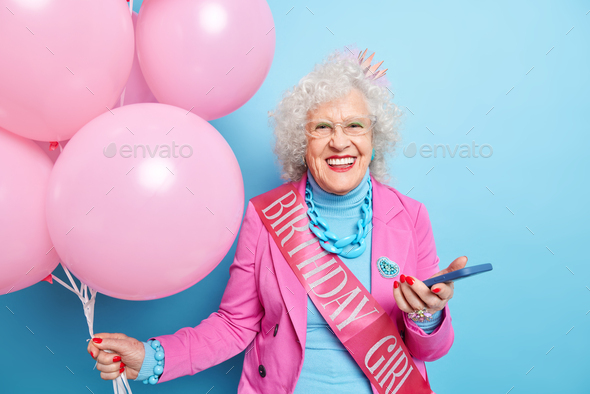 Portrait of fashionable elderly lady celebrates her anniversary receives messages of congratulations