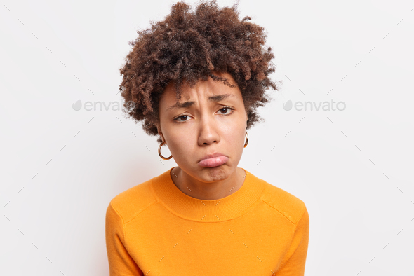 Close up shot of discontent sad Afro American woman being dissatisfied offended by someone dressed i