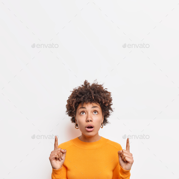 Impressed Beautiful Afro American Woman Looks Shocked Above Indicates