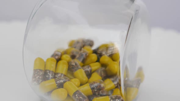 Shot of yellow and brown granule capsule in a glass bottle alt