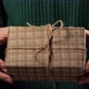 Girl  hand holding a gift wrapped in striped brown paper tied with a rope - VideoHive Item for Sale