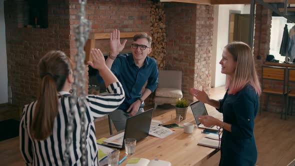 Diverse Team Applauds To Manager in Startup Loft Office and Gives High Five