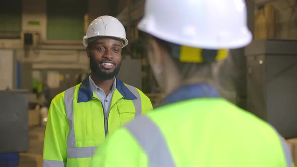 Diverse Engineers Chatting and Hugging During Break at Factory alt