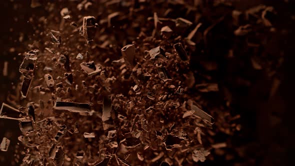 Super Slow Motion Shot of Raw Chocolate Chunks and Cocoa Powder Flying Towards Camera at 1000Fps alt