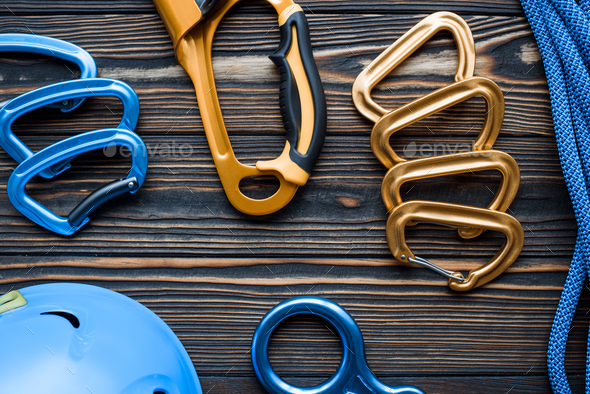 Isolated photo of climbing equipment. Parts of carabiners lying on the wooden table