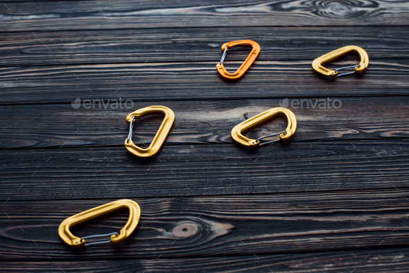 Isolated photo of climbing equipment. Parts of carabiners lying on the wooden table