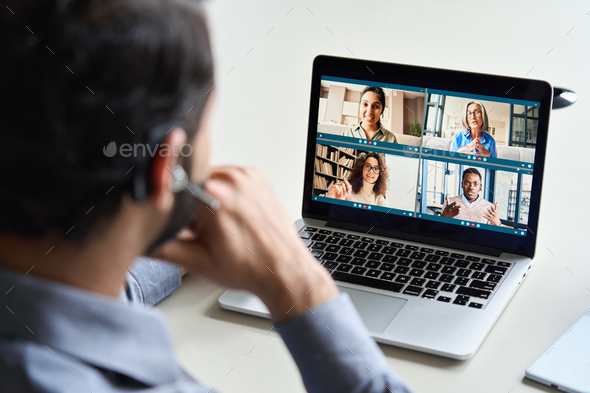 Indian business man wearing headset having virtual team meeting on video call.