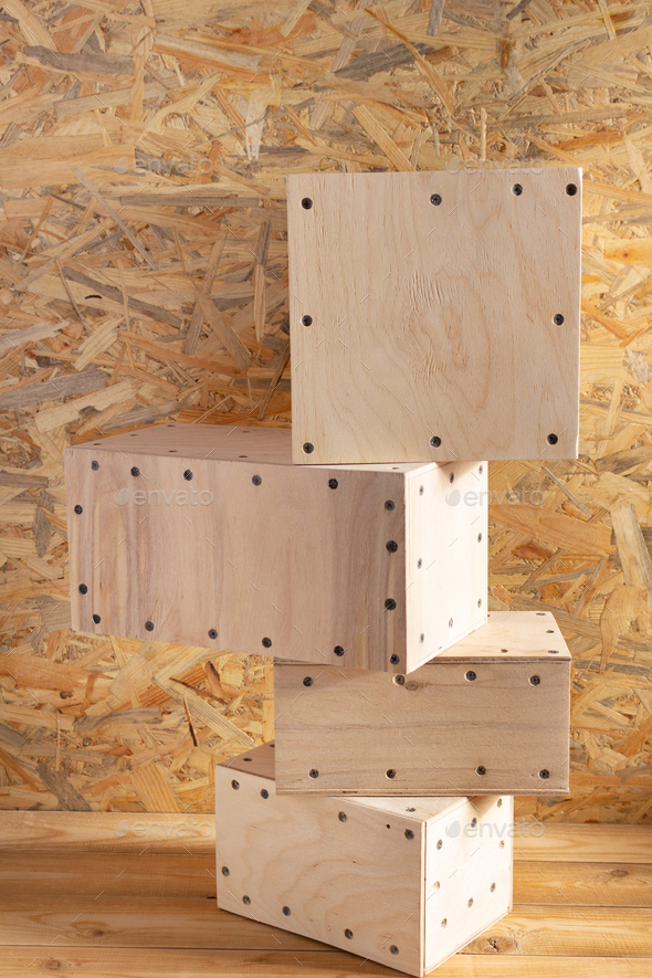 Stack of wooden cube or plywood box block near wall background texture. Construction concept