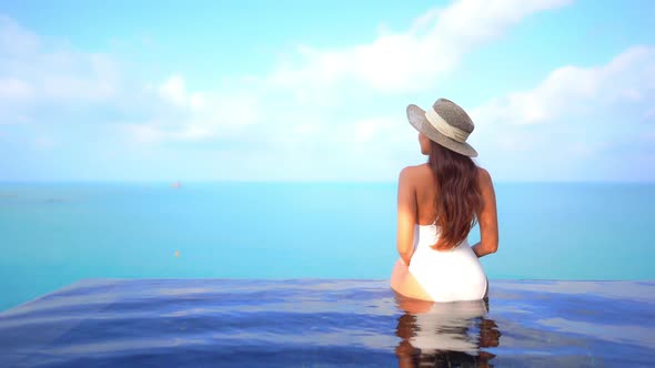 Young asian woman enjoy around outdoor swimming pool for leisure alt