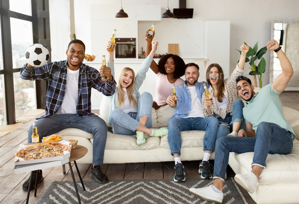 Friends Cheering While Watching Football On Tv Stock Photo