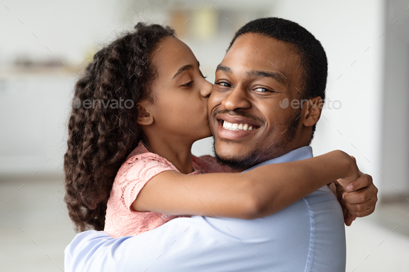 Cute black girl kissing her smiling father, closeup - Stock Photo - Images