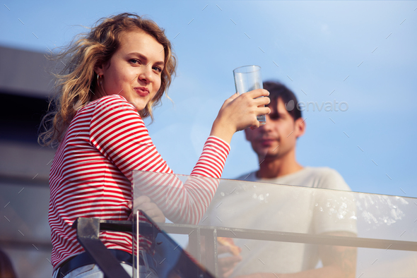 Pleasant young woman drinking juice on the rooftop